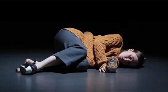 Actress lying on floor with crystal ball